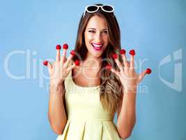 I give healthy food ten out of ten. Studio shot of a woman posing with raspberries on her fingertips against a blue background.