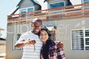 Weve secured the house of our dreams. Portrait of a young couple holding the keys to their new home.