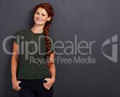 Feeling like a princess. Studio portrait of a beautiful young woman with her long red hair in a braid.