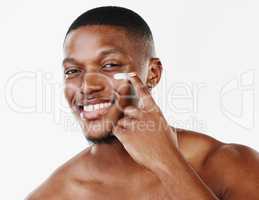 Wishing you could make this yours. Studio portrait of a handsome young man applying moisturiser against a white background.