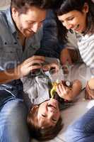 Children have a special way of adding joy to your lives. Cropped shot of happy parents bonding with their son at home.
