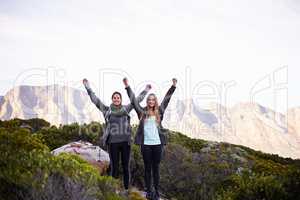 We made it to the top. Portrait of two excited young female hikers in the outdoors.