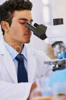 Hard at work in the lab. Shot of a lab technician using a microscope while sitting in a lab.