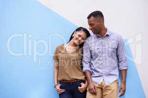 Shes the only one for me. Portrait shot of a young couple leaning against a colorful wall.