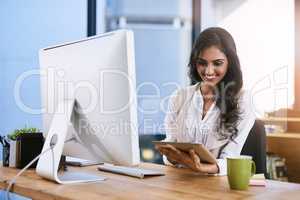 Passion is the spark that illuminates your path to success. Shot of a businesswoman using her digital tablet while sitting at her desk.