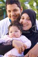 She brights up every day. Portrait of a muslim family enjoying a day outside.
