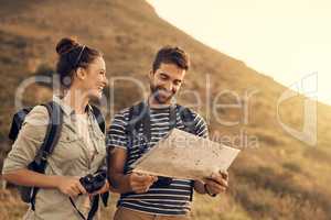 Do you even understand maps, babe. Shot of a couple looking at a map while out hiking.