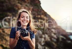 Theres so much to explore and capture in the world. Portrait of a young woman taking photos with her camera outdoors.