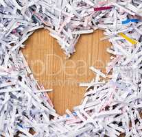 I love shredded paper. Studio shot of shredded paper arranged in the shape of a heart on a wooden table.