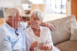 Its a faster way to share funny messages. Shot of a senior couple using a cellphone together.