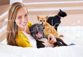 I guess Im an animal person. Portrait of an attractive young woman sitting with her pets on the sofa.