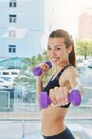 Ive been hit by the fitness bug. Portrait of an attractive young woman working out with dumbbells at home.