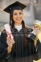 Shes achieved outstanding merit. Portrait of a student holding her diploma and trophy on graduation day.