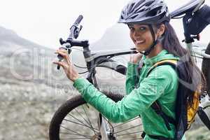 I am an adventurer. A pretty young woman carrying her mountain bike.