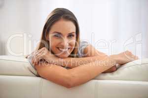 Enjoying sofa time. Portrait of a comfortable woman sitting in her living room.