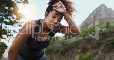 The path to a healthier lifestyle doesnt come without challenges. Shot of a sporty young woman taking a break while exercising outdoors.