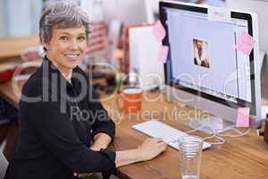 Years of experience make her successful. Portrait of a mature woman sitting at her desk in an office.