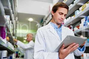 Dispensing duties just got smarter. Shot of a young pharmacist using a digital tablet in a pharmacy.