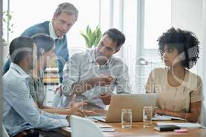 Technology brings their ideas to life. Shot of a group of professionals using wireless technology during a meeting.