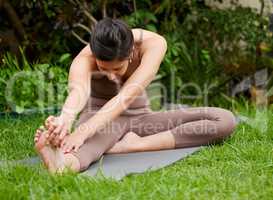 Regular movement is good for your body. Shot of a young woman stretching her legs while exercising outdoors.
