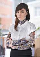 Shes ready to rock the corporate scene. A tattoo-covered young businesswoman in her office.