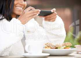 Have to get a picture for my socials. Shot of a young woman taking a picture of a plate of food.