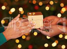 Tis better to give than to receive. Shot of two unrecognizable women exchanging gifts at Christmas.