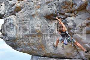 Determined to reach the top. A young rock climber scaling a mountain - copyspace.