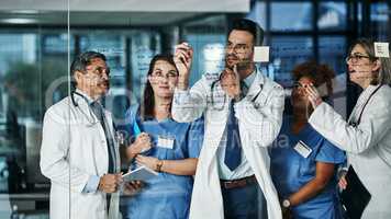 Medical brainstorming brilliance. Shot of a team of doctors having a brainstorming session in a hospital.