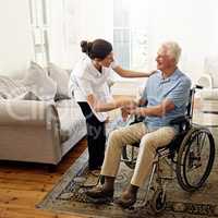 Taking care of the elderly is her calling. Shot of a caregiver helping a senior man in a wheelchair at home.