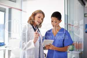 I want you to do the following.... Shot of a female doctor giving a nurse instructions at a hospital.