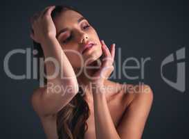 Charm them with your confidence. Studio shot of an attractive young woman posing against a dark background.