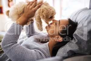 Dogs just need you and love, thats all. Shot of a young woman relaxing with her dog at home.