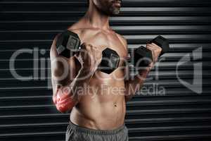 Pushing himself a little too far. Studio shot of a muscular young man lifting dumbbells with cgi highlighting his elbow.