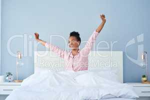 Wake up Its time to take on the world. Shot of a happy young woman waking up in bed in the morning.