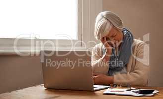 Retirement fund worries.... An elederly woman sitting in front of her laptop looking stressed and worried.