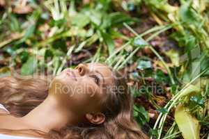 Getting back to nature. A beautiful young woman lying on the forest floor.