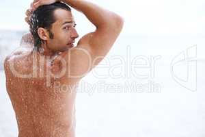 Sexiness is next to cleanliness. Shot of a handsome young man enjoying a refreshing shower.