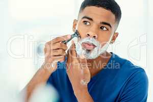 What a good time for the weekly shave. Shot of handsome young man beginning to shave his face.