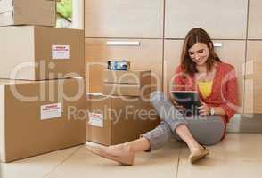 Researching the most stylish interior design and decor ideas. Shot of a young woman taking a break while moving into her new home.