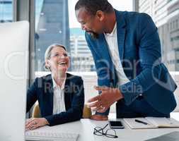 Youve got the best approach to problems. Shot of two businesspeople having a discussion in the office while using a computer.