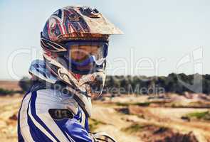 Time to rip up this track. Portrait of motocross rider looking back.