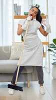 I cant help but sing when I see a clean house. Full length shot of an attractive young woman standing and singing while using a broom to sweep her home.