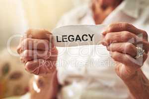 May your legacy last forever. Cropped shot of an elderly woman holding a piece of paper with the word legacy on it.