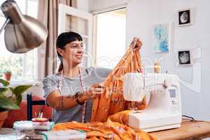 This skirt will be trending as soon as I post it. Shot of a beautiful young woman working on a garment at home.