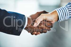 Making a big merger happen. Closeup shot of two businesspeople shaking hands in an office.