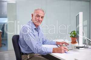 Experience is his most valuable asset. Portrait of a mature businessman working at his office desk.