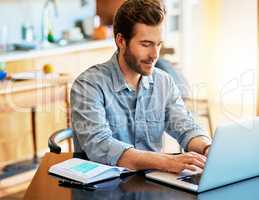 Freelancing offers a lot of freedom and flexibility. Shot of a handsome young man working on a laptop at home.