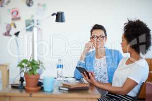 Shot of an attractive young woman sitting at her workstation in the office. The commercial designs displayed in this image represent a simulation of a real product and have been changed or altered enough by our team of retouching and design specialists so