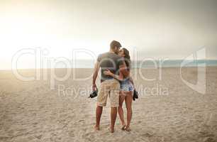 Romantic seaside strolls at sundown. Shot of a young couple spending a romantic day at the beach.